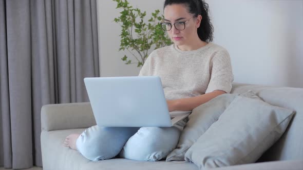 Concerned Thoughtful Caucasian Woman Working on Laptop Computer Looking Away Thinking Solving