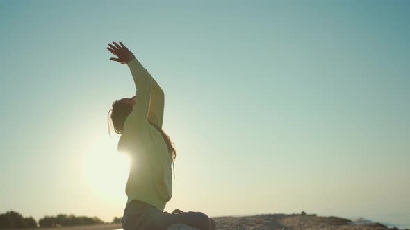 Pretty Confident Woman Doing Yoga and Meditation Practicing at Sunrise on Beach