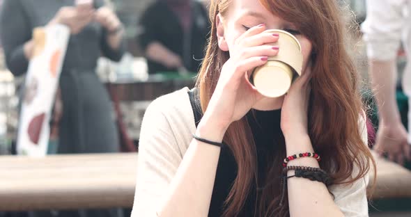 Happy young woman drinking a coffee in the city
