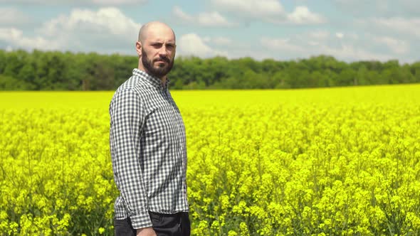 Agronomist Examining Blossoming Canola Field