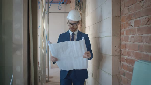 Owner Examining Renovation Blueprint on Construction Site alt