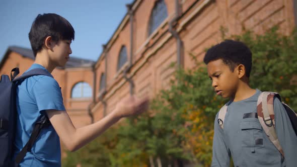 Side View of Diverse School Friends Doing Special Hand Greeting Outdoors