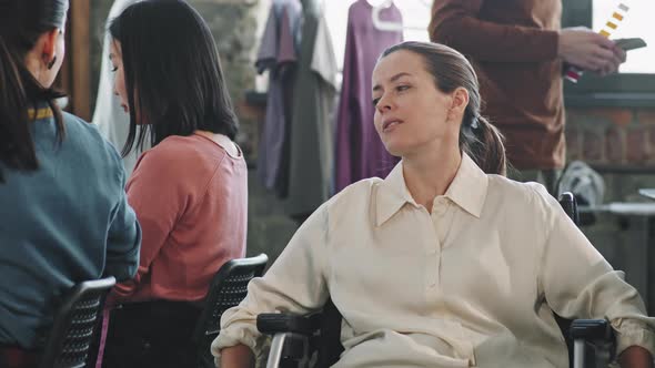 Woman in Wheelchair Talking to Seamstress in Workplace