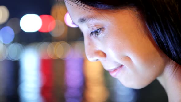 Woman travel in Hong Kong and using smart phone at night 