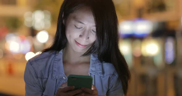 Woman using mobile phone at night 