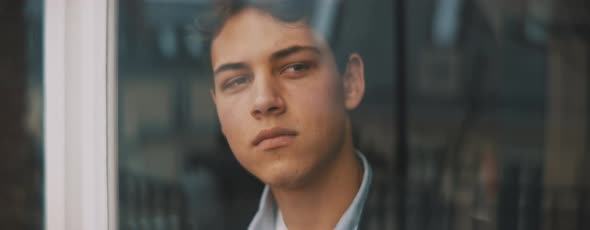 Young european man looking around from the window