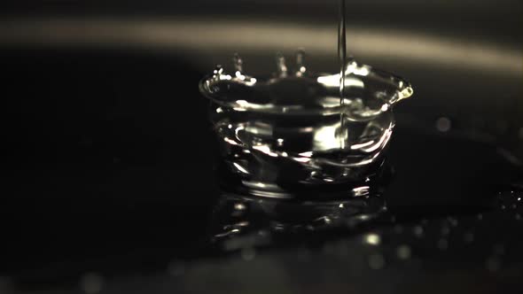 Super Slow Motion Jet Oil Falls on the Pan with Splashes