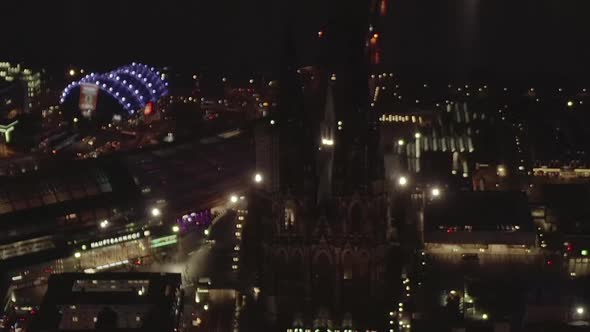 AERIAL: Beautiful Wide Shot Over Cologne Germany at Night Time with City Lights 