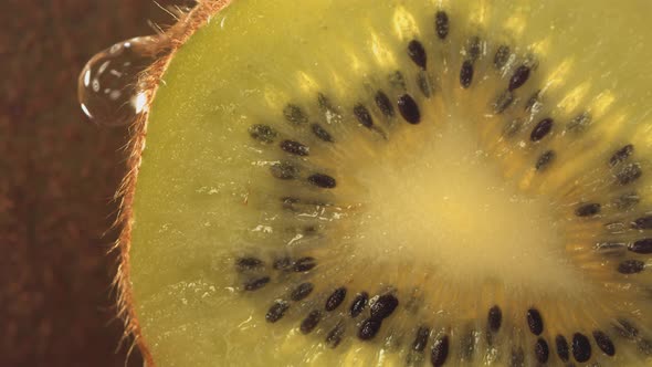 Drop of Water Flows Down the Surface of a Ripe Juicy Kiwi Slice