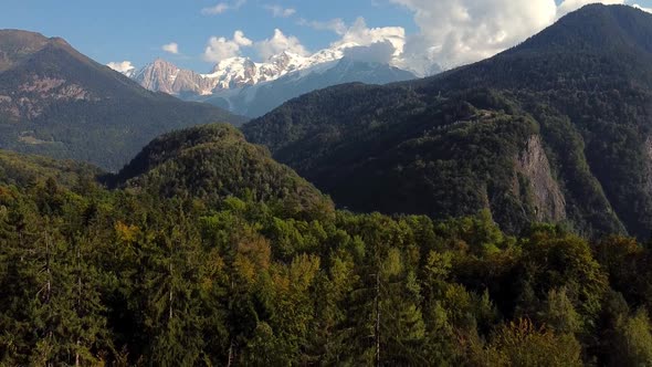 Flying downwards over a fir forest. Nice mountains landscape. Montblanc chain, french Alps. Autumn c