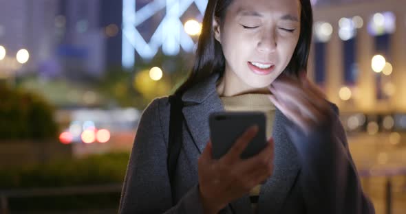 Woman use of smart phone in city at night