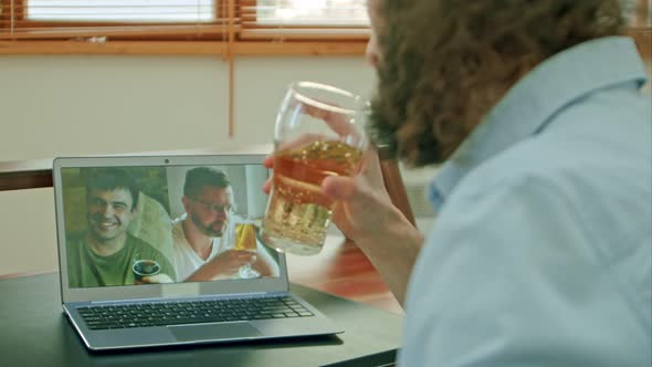 Man Chatting with Friends Video Call and Drinking Beer