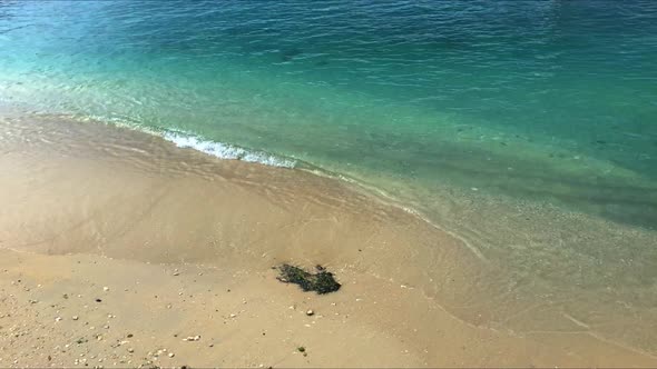 aqua blue waves lapping the sandy beach in the Caribbean.