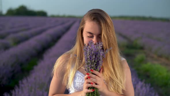 Young Smiling Caucasian Woman Holding a Bouquet of Fragrant Flowers Looking at the Camera Lavender