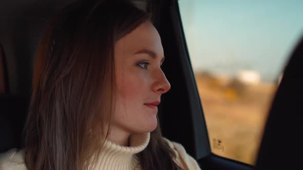 Young Girl Rides in a Car and Looks Out the Window