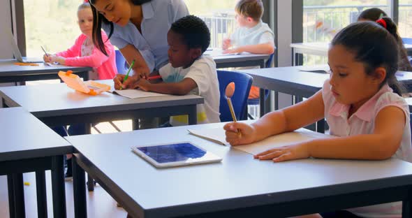 Female teacher explaining schoolboy in the classroom at school 4k