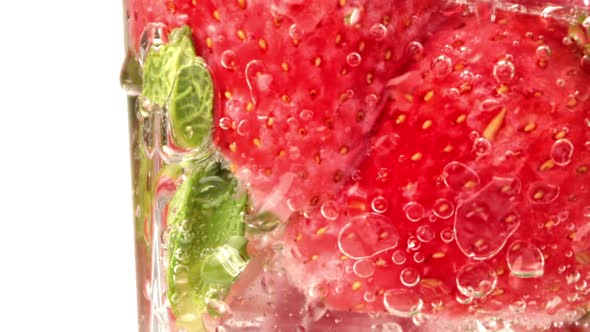 Extreme Closeup Rotation Appetizing Refreshment Summer Cocktail Ice Strawberry and Mint Leaves