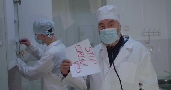 Doctor Shows to Camera Inscription "Stop Coronavirus"