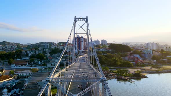 Aerial drone scene of suspension bridge hercilio luz revealing its structure and the city in the bac