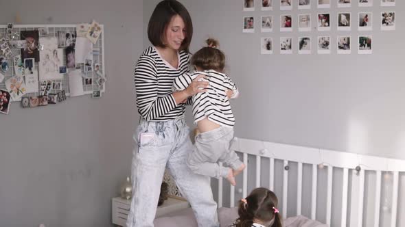 Modern Mother of Two is Playing with Her Little Daughter Swinging Her and Tickling in Slow Motion