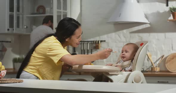 Mother Feeding Her Baby in Kitchen