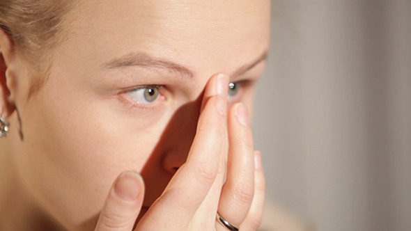 Young Woman is Putting Cosmetic Cream on her Face 2