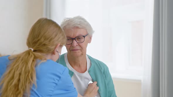 Senior woman patient undergoes examining with stethoscope