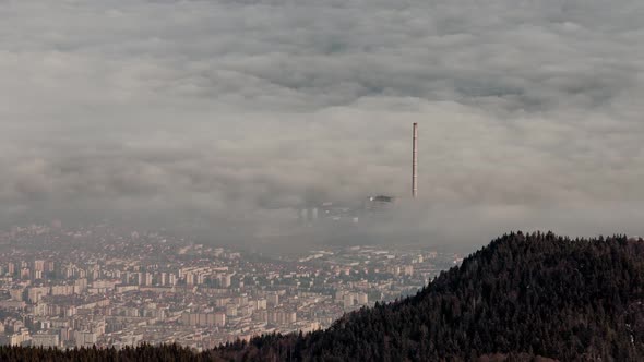 Top of the mountain view with fog waves over a big city