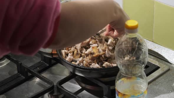 Young Woman Preparing Fried Mushrooms with Cheese and Meat at the Home Kitchen