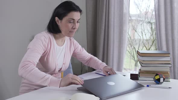 Young Beautiful Caucasian Woman Coming To Table, Opening Laptop and Peeking at Social Media of Her