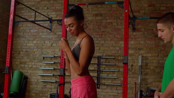 Active African American Female Boxer Practicing Boxing Techniques with Coach