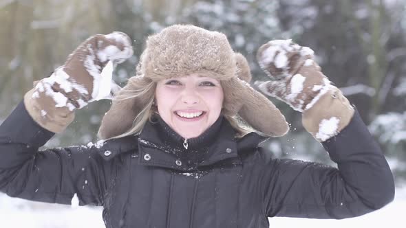 Happy Young Woman Playing Outdoors in the Snow on Winter Holiday Season