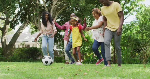 Animation of happy african american family playing football in garden