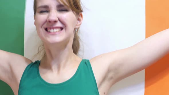 Irish Young Woman Celebrating While Holding the Flag of Ireland in Slow Motion