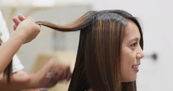 Woman having hair straightening treatment in hair salon