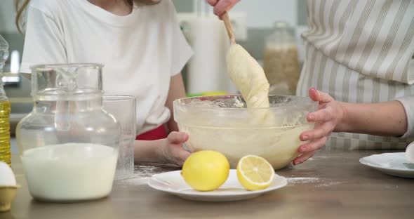 Mother and Daughter Child Together at Home Kitchen Kneading Dough in Bowl, Close-up