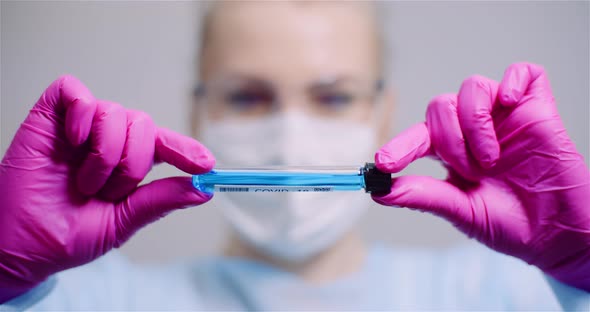 Working in Lab - Scientist Holding Test Tubes. Positive Test of COVID-19 Coronavirus at Laboratory.