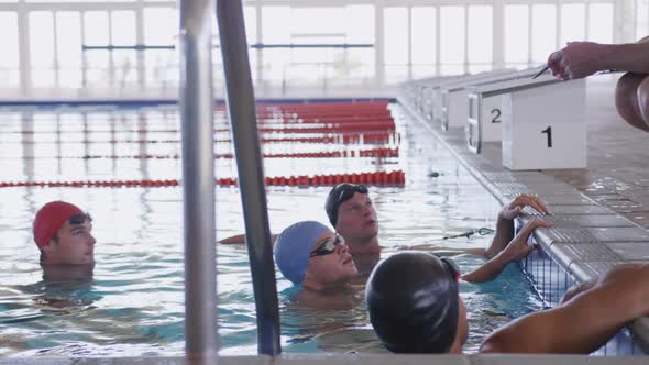 Swimming coach talking to swimmers