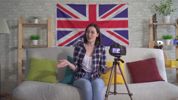 Young Woman Blogger in Shirt on the Background Flag United Kingdom Recording Video