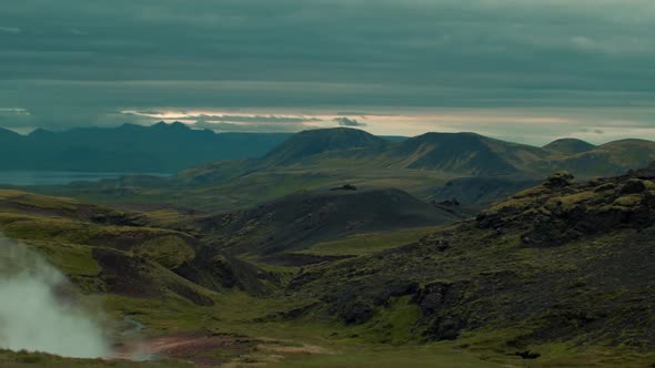 iceland landscape, geothermal hotspring steam smoke rising, camera pan from right to left, wide angl