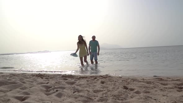 Romantic Couple Running on Beach at Sea Sunset Holding Hands