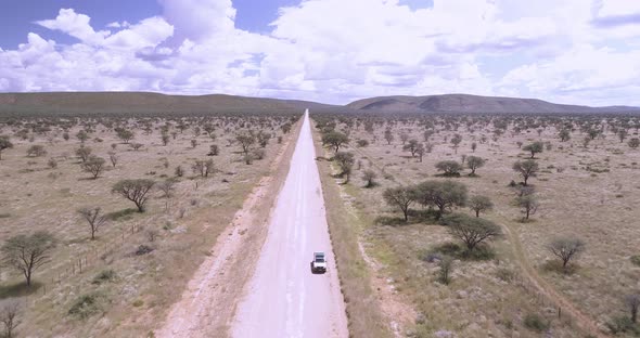 Truck driving down an isolated road in Namibia.