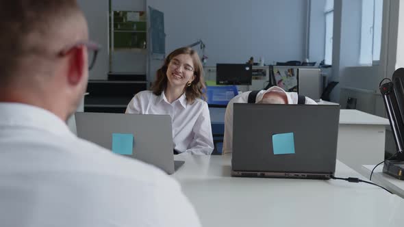Coworkers Cheerfully Smiling While They Work Together