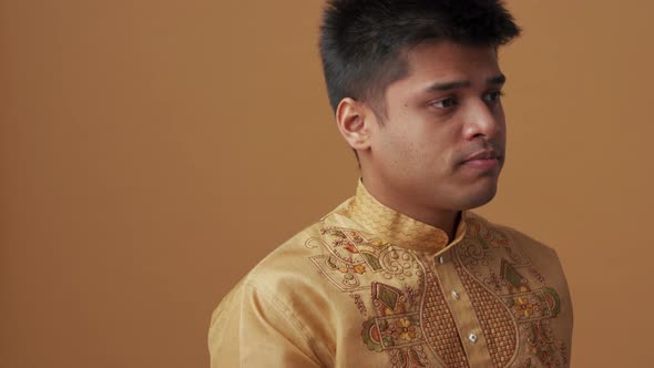 Confident Indian man in national cloth touching his temples