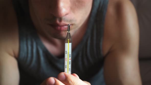 Close-up. The guy holding a thermometer