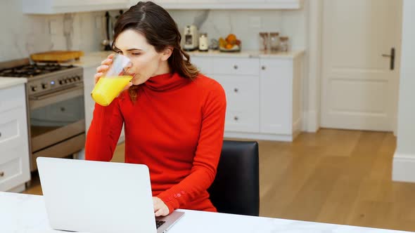 Woman using laptop in kitchen