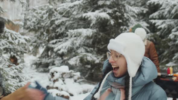 Joyful Girlfriends Greeting Each Other at Campsite in Winter Forest