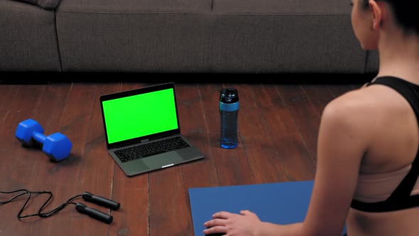 Green Screen Laptop Concept Woman Sits on Yoga Mat Watch Sport Online Course