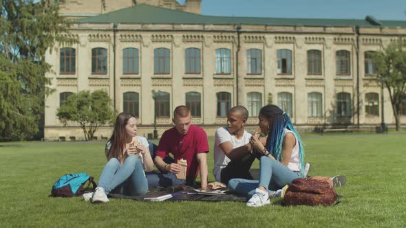 Young Diverse Students Having Snack on Campus Lawn