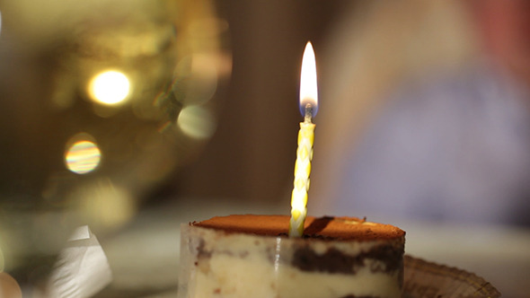 Glass of Champagne and Candle in Tiramisu Cake